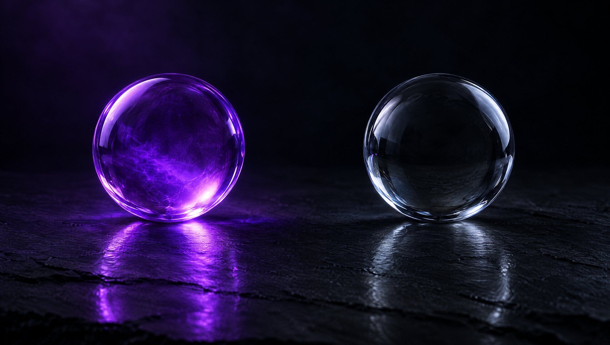 Two clear glass spheres on dark slate, the left glowing violet from within and the right cool and grey.